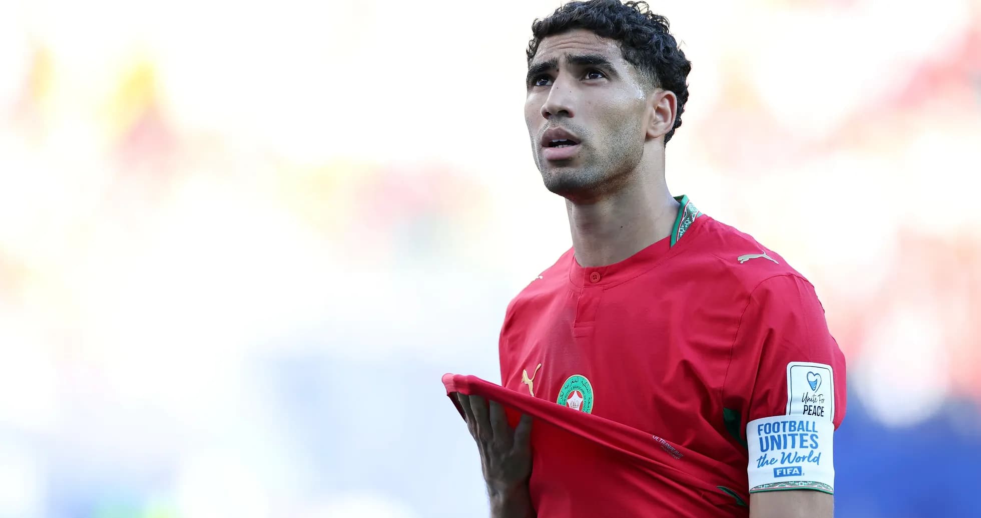 Player adjusting shirt during match in red uniform