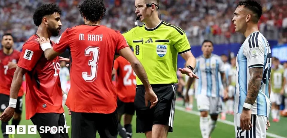 Players and referee discussing during tense match moment