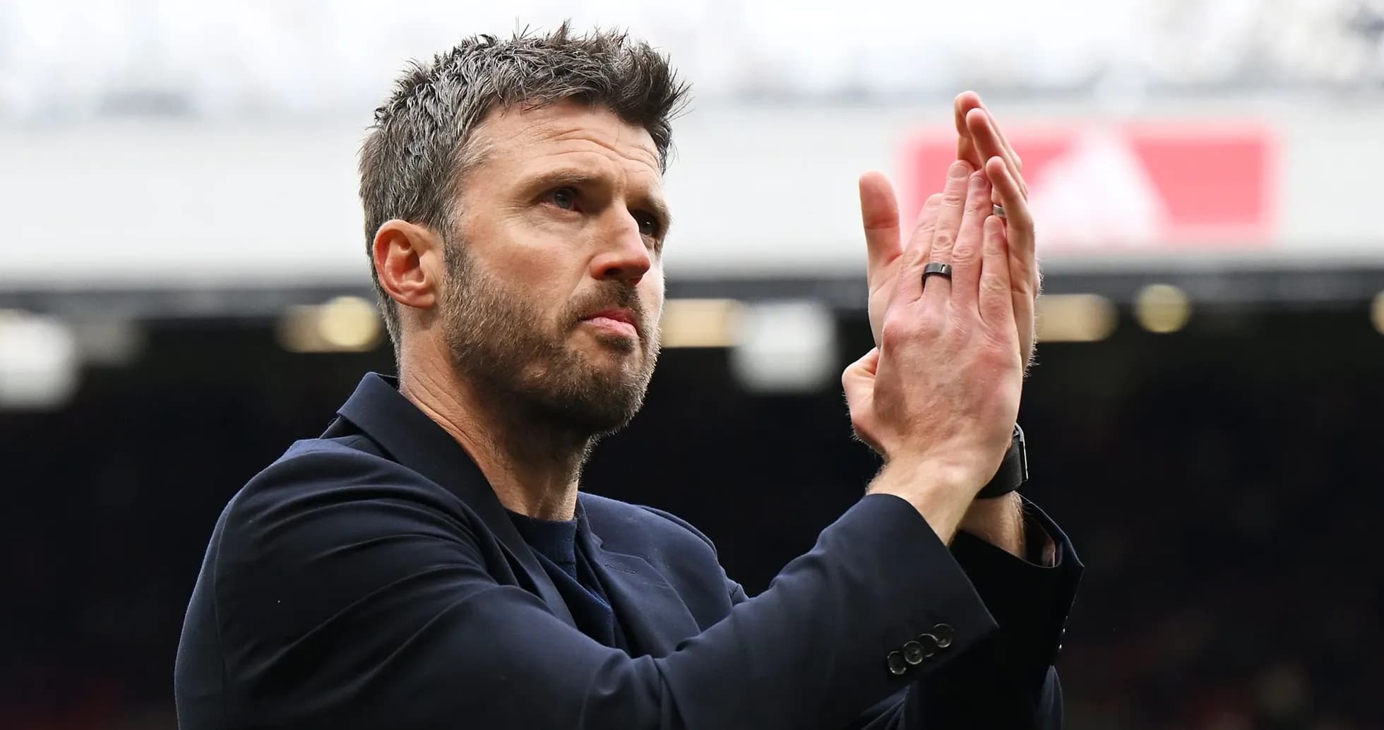 Coach applauding fans in stadium stands