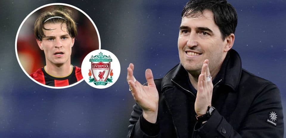 Manager applauding with player and Liverpool logo in background