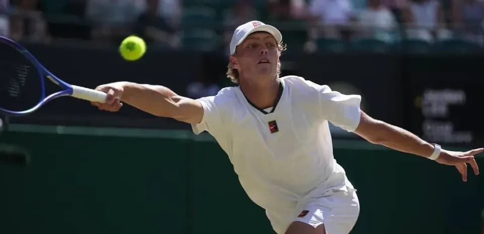 Player stretching to hit a tennis ball during match