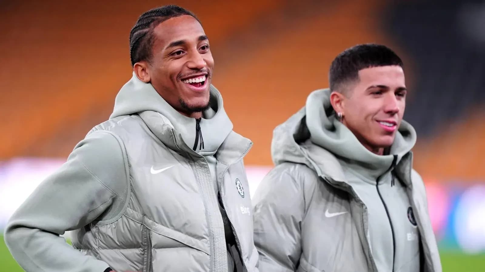Two players smiling in matching team jackets
