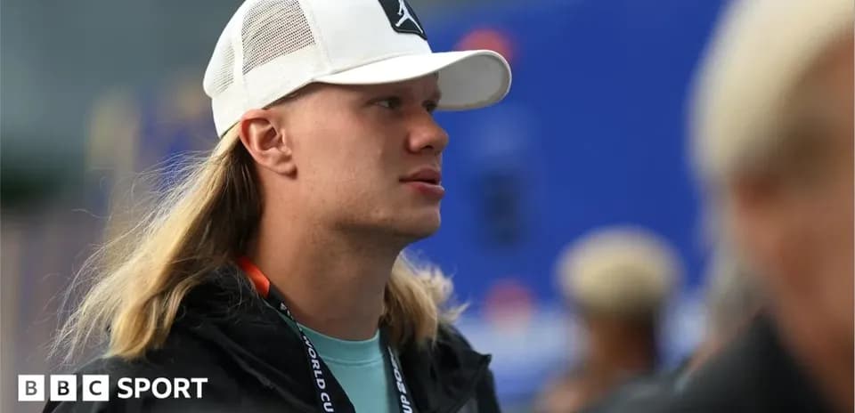 Individual with long hair wearing a white cap