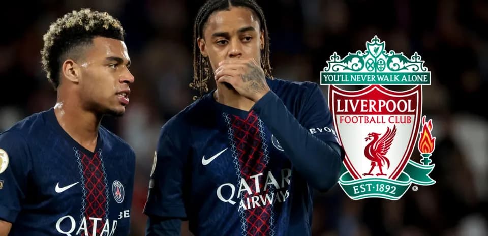 Two players discussing during match with Liverpool logo