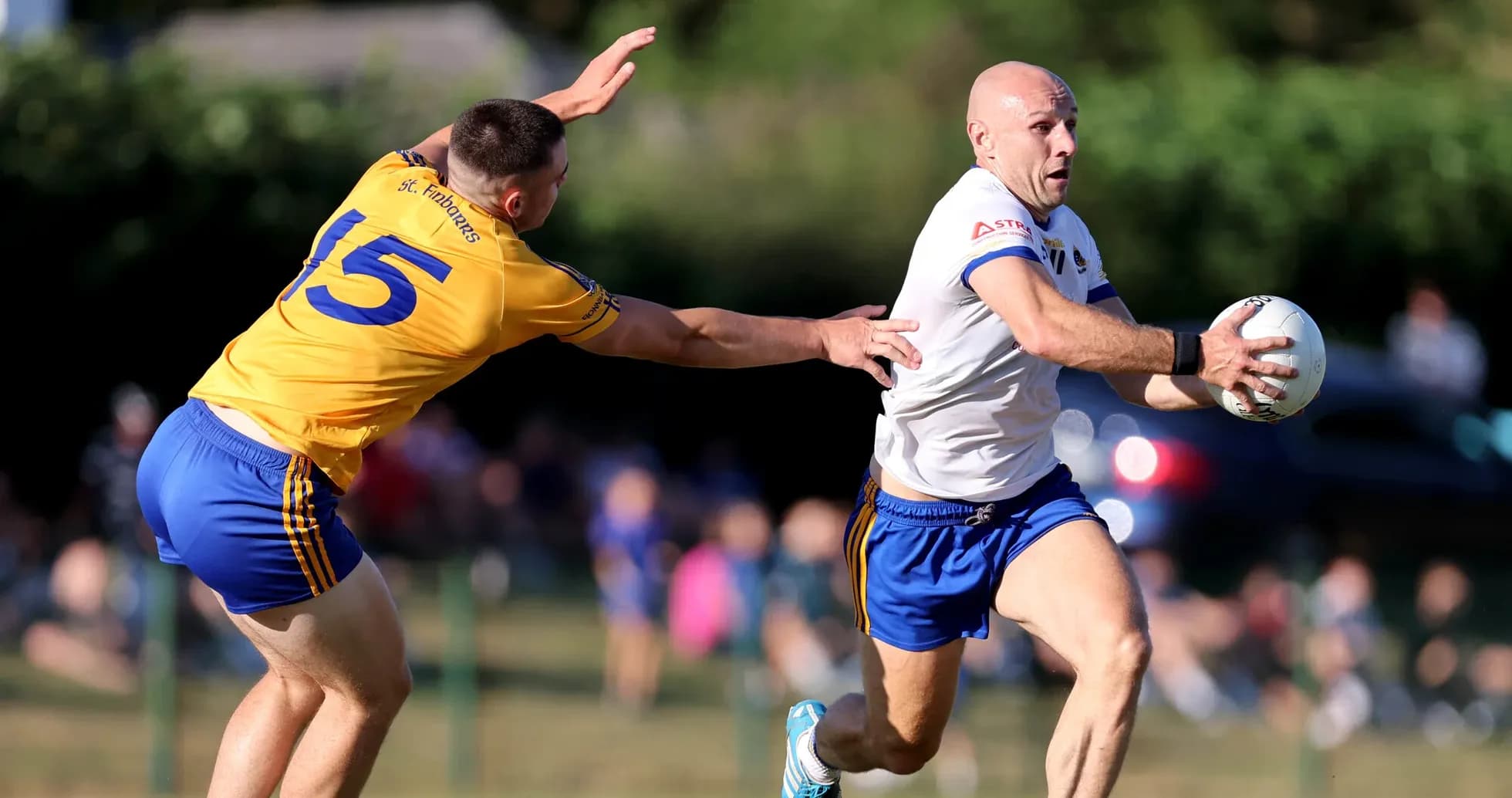 Player running with the ball, opponent reaching to tackle