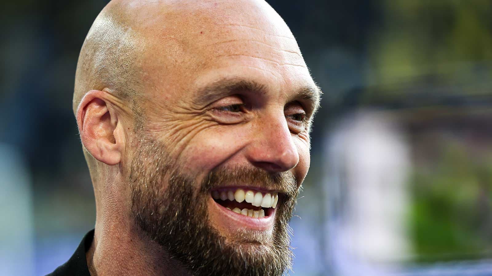 Coach smiling during press interview outdoors
