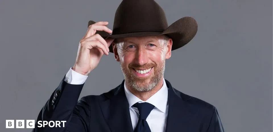 Man in suit and cowboy hat smiling