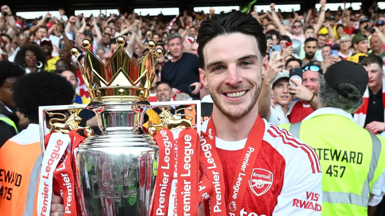 Player celebrating with Premier League trophy and fans Player celebrating with Premier League trophy and fans