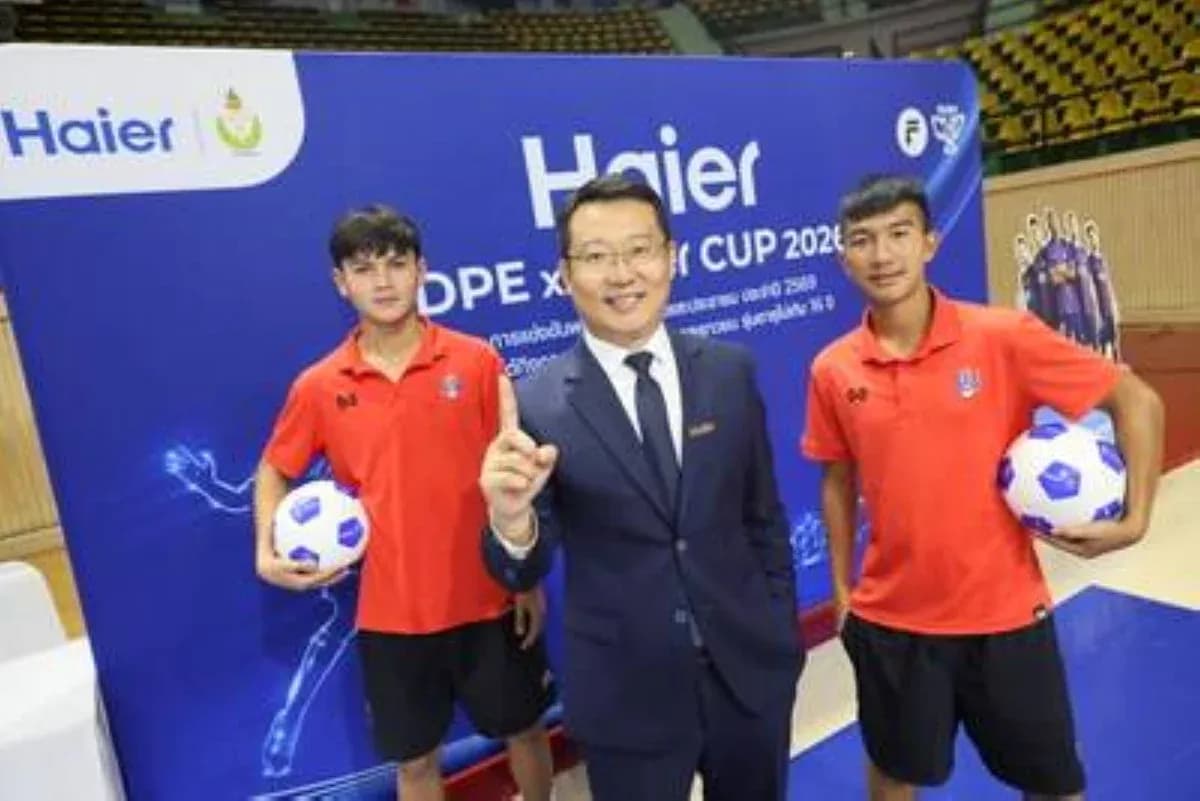 Two young football players with a representative at event Two young football players with a representative at event