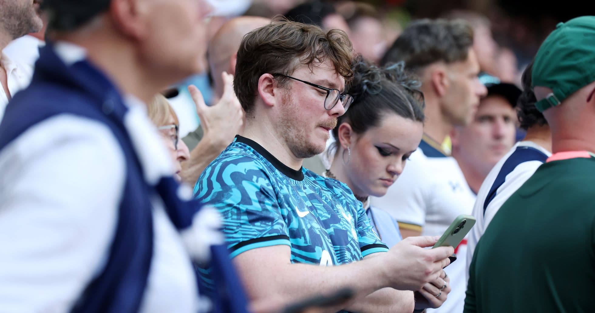 Fans watching the match and using their phones Fans watching the match and using their phones