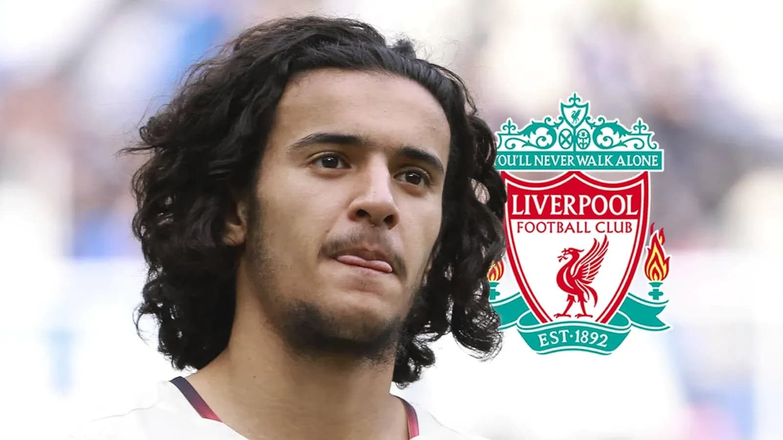 Player with curly hair next to Liverpool FC logo Player with curly hair next to Liverpool FC logo