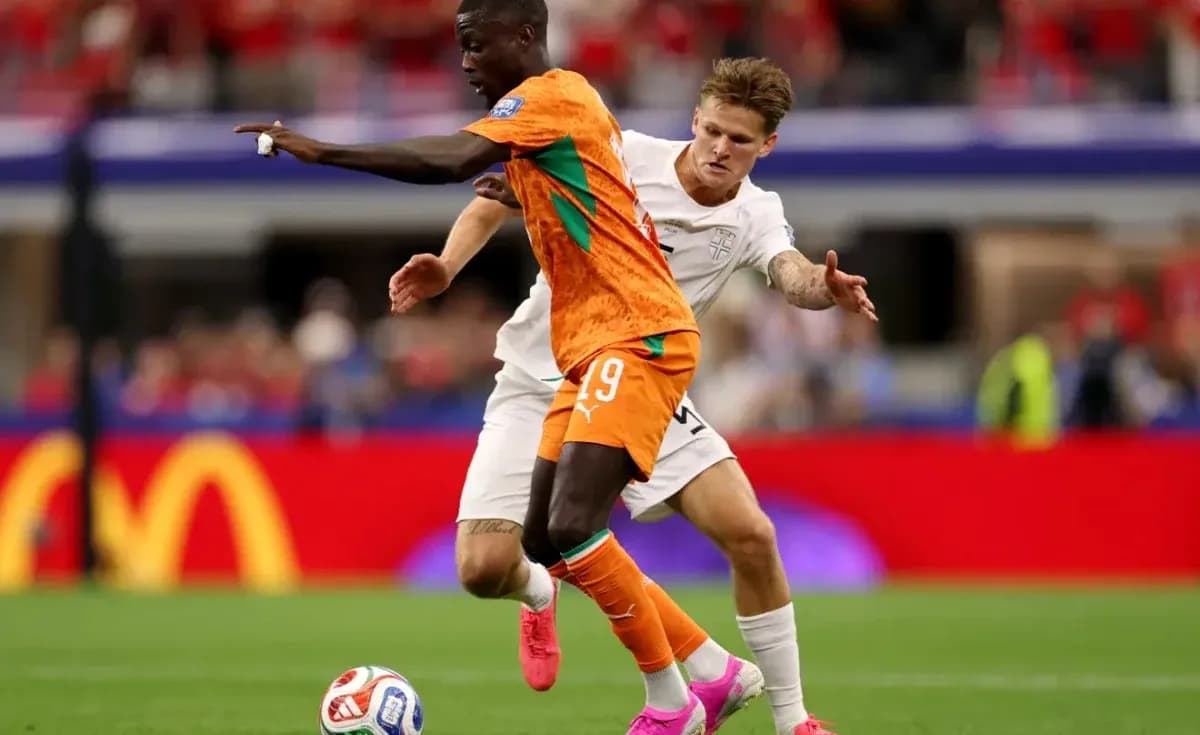 Player in orange jersey dribbling past opponent in white Player in orange jersey dribbling past opponent in white