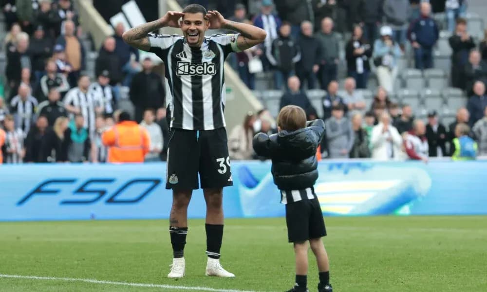 Newcastle player celebrating with young fan on pitch Newcastle player celebrating with young fan on pitch