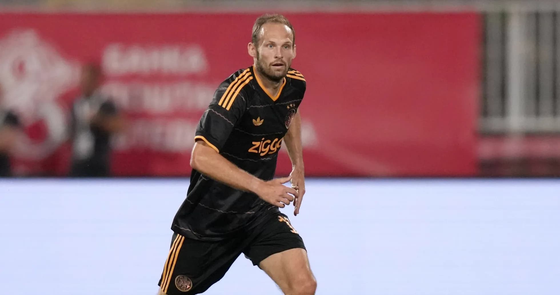 Player in black kit running on the pitch Player in black kit running on the pitch