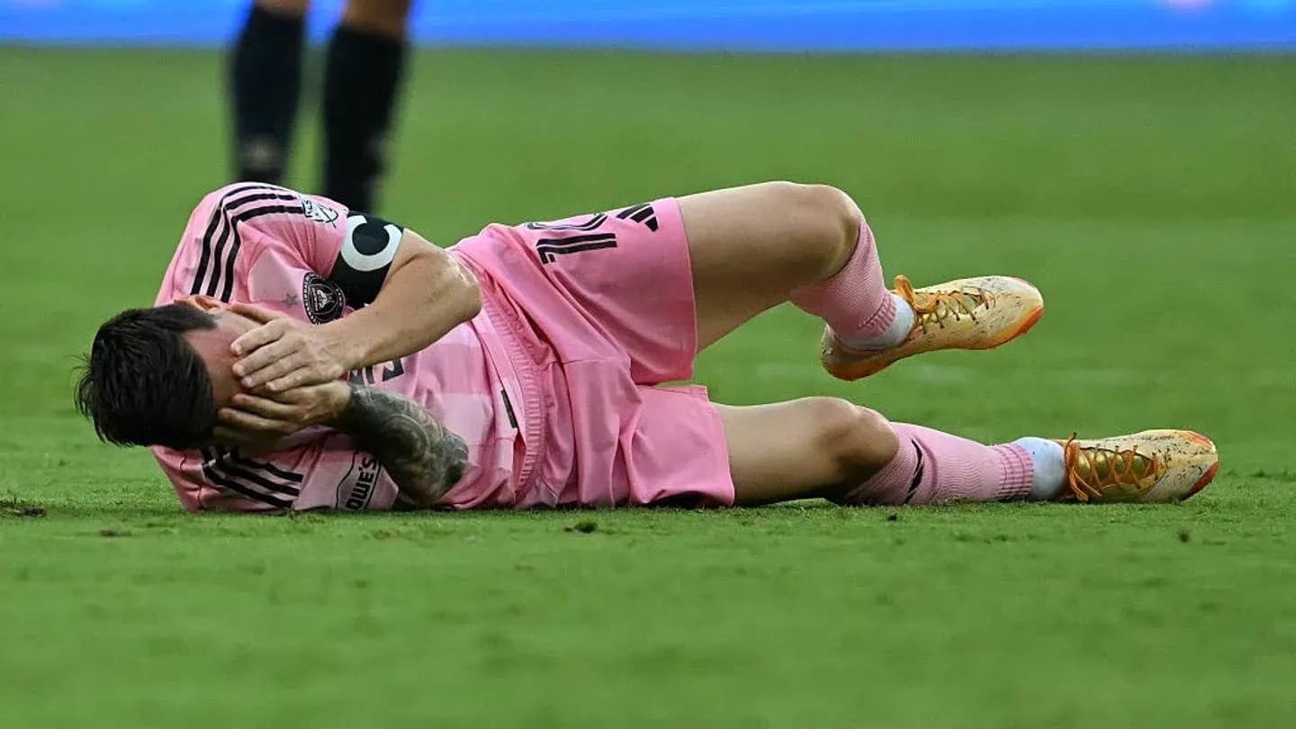 Player lying on the field, holding his face Player lying on the field, holding his face