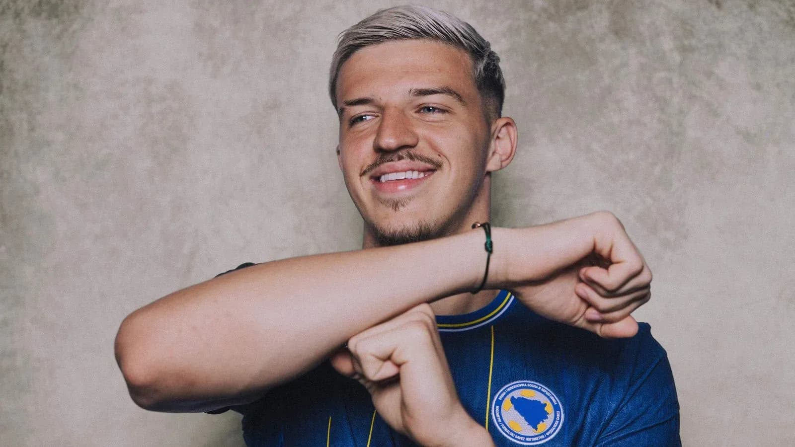 Player in blue jersey smiling and gesturing Player in blue jersey smiling and gesturing