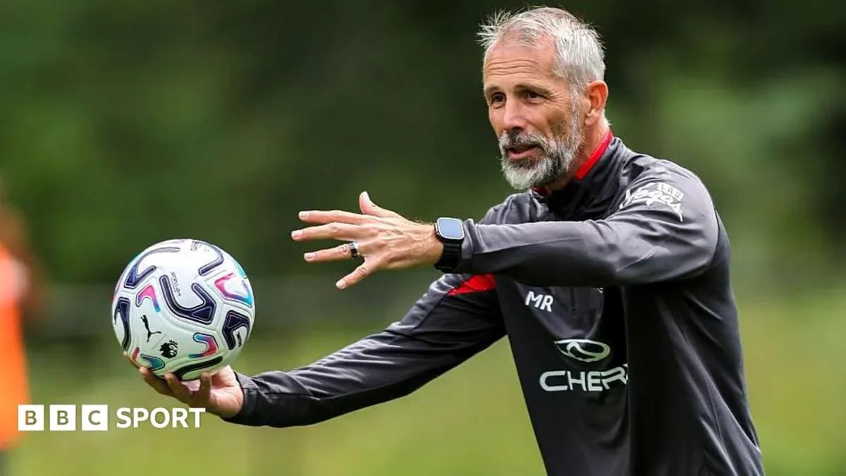 Coach instructing players while holding a football Coach instructing players while holding a football