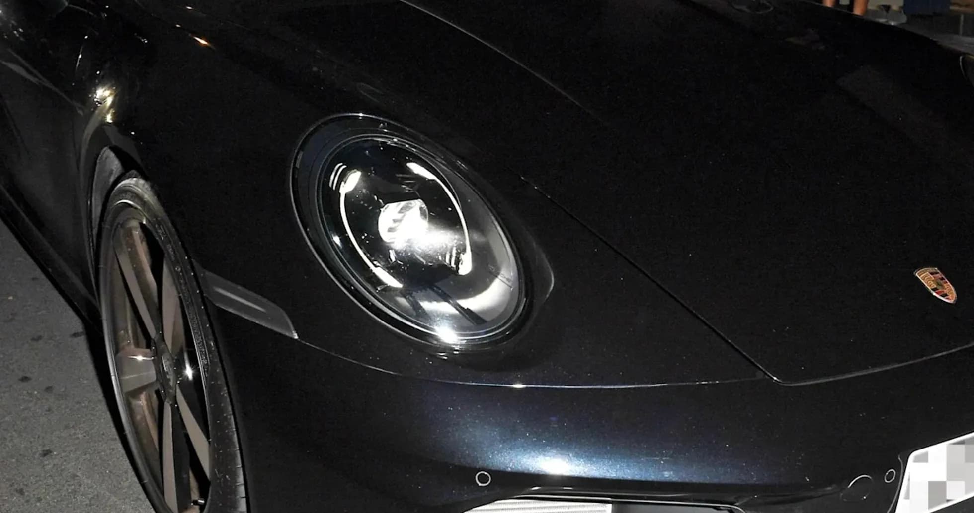 Two men inside a black Porsche at night Two men inside a black Porsche at night