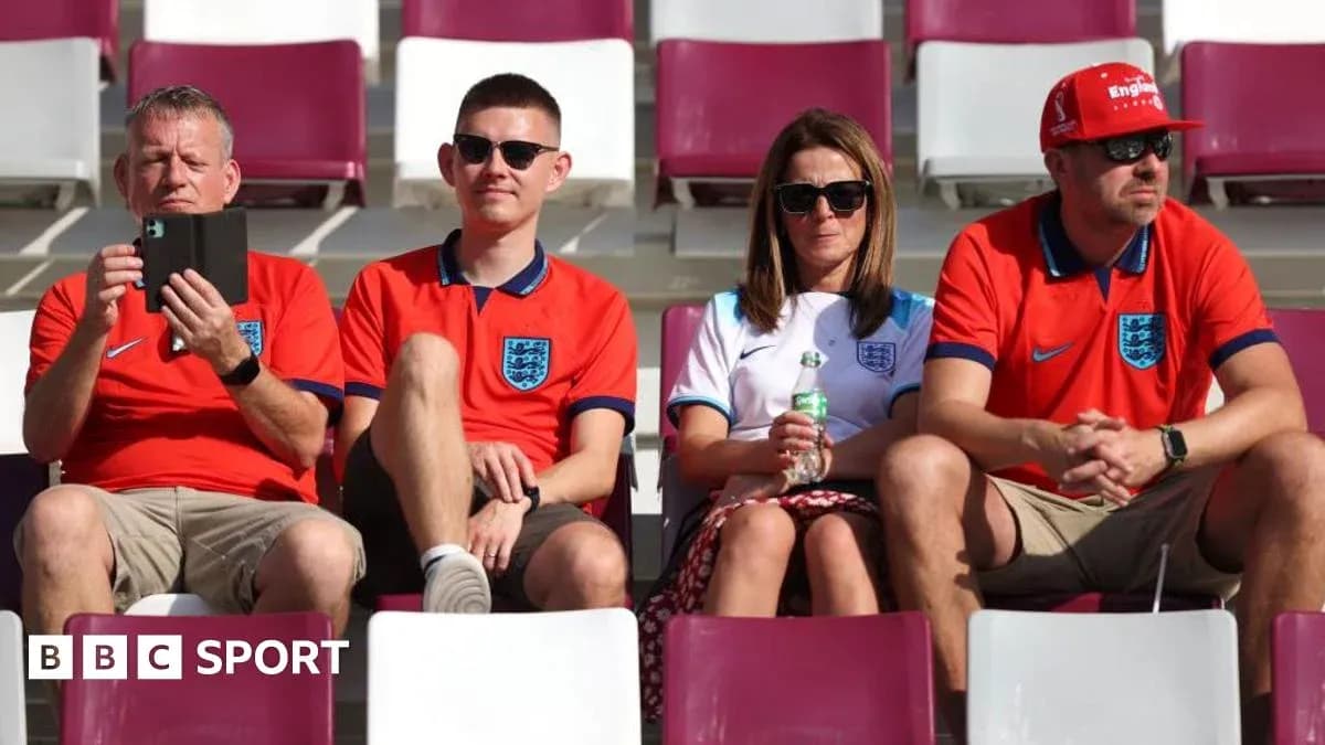 Fans in England jerseys seated in stadium stands Fans in England jerseys seated in stadium stands