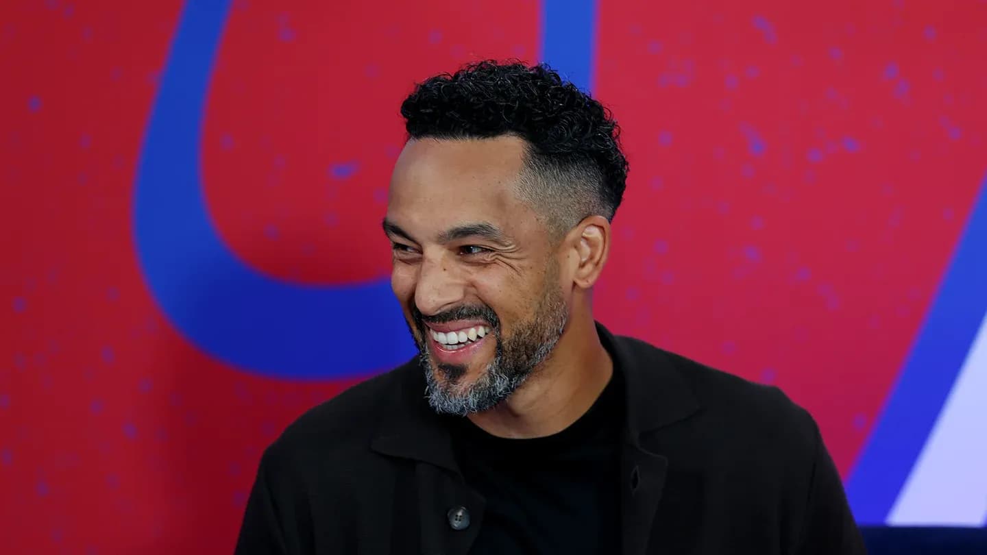 Man smiling during an event with colorful background Man smiling during an event with colorful background