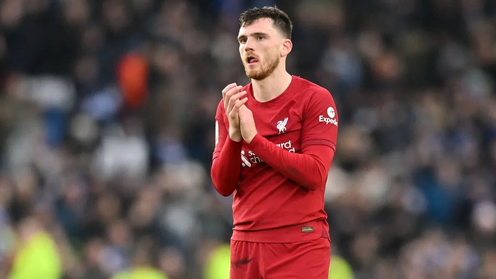 Player in red jersey applauding fans after match Player in red jersey applauding fans after match