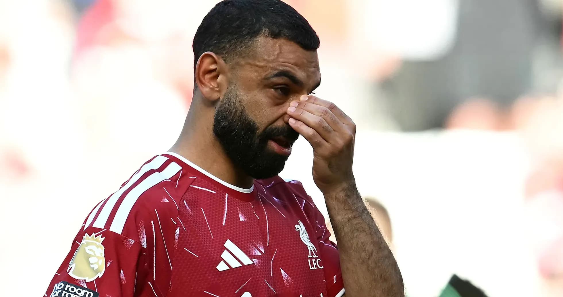 Player in Liverpool jersey wiping his face Player in Liverpool jersey wiping his face