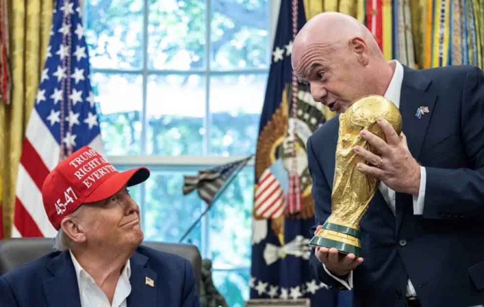 Person holding FIFA World Cup trophy in office Person holding FIFA World Cup trophy in office