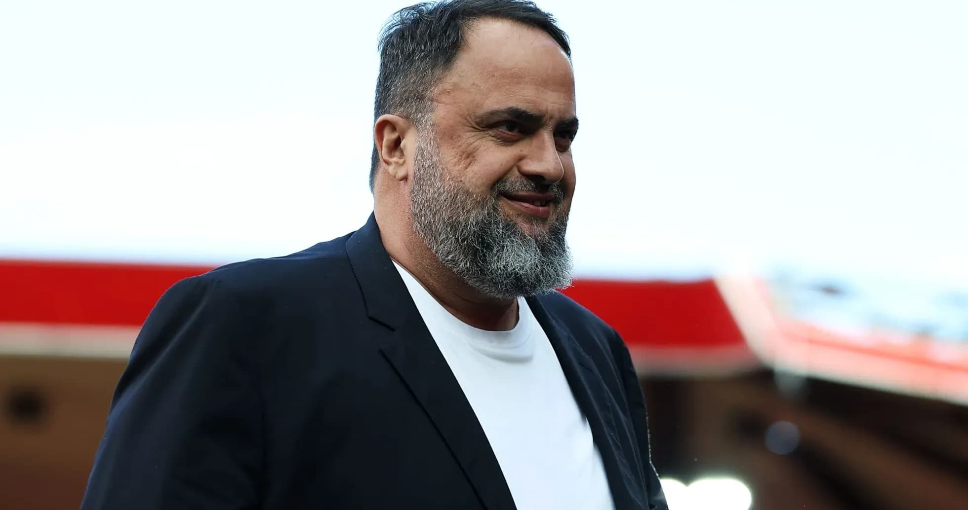 Man with beard walking in a stadium setting Man with beard walking in a stadium setting