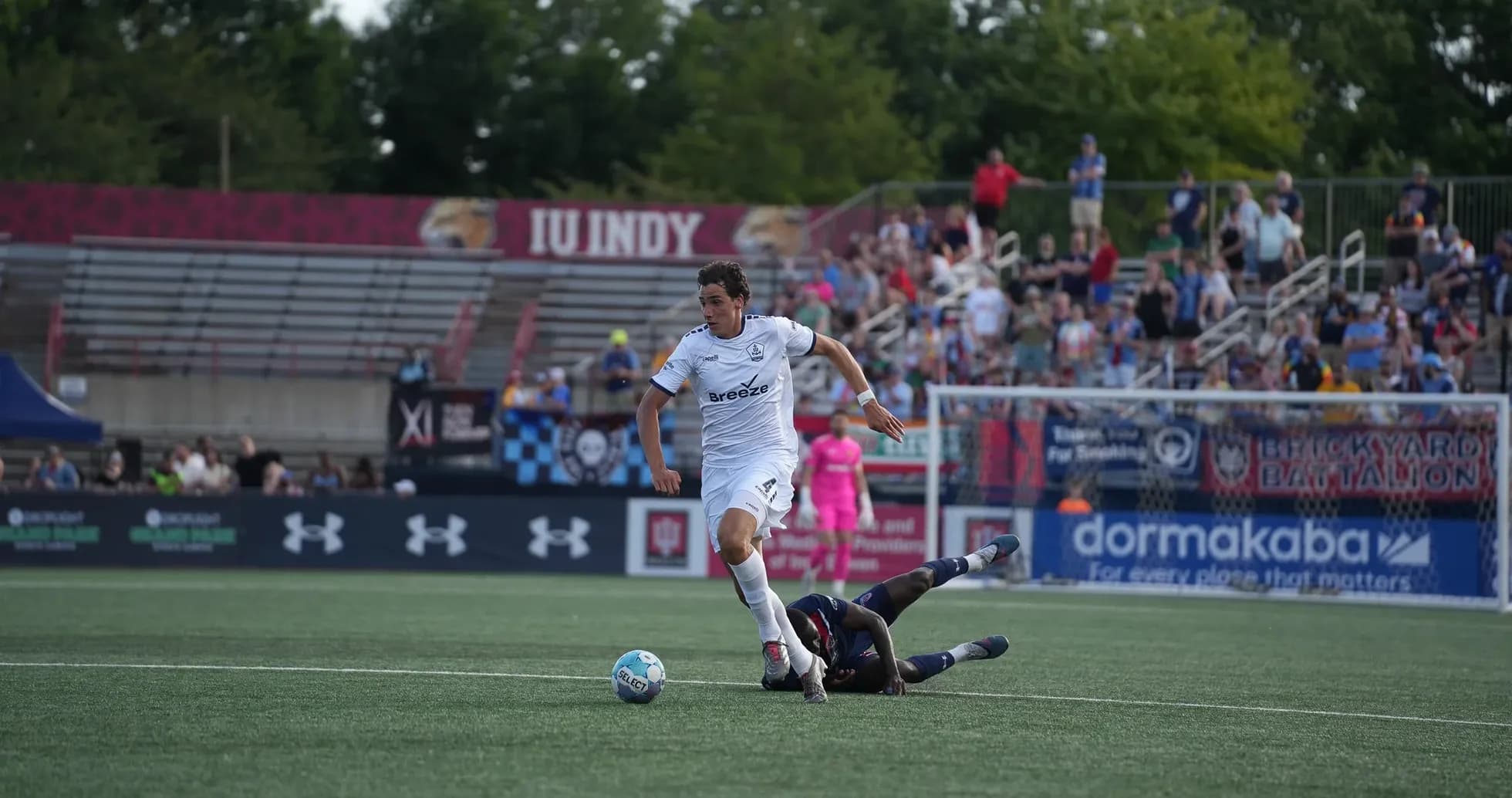 Player dribbling past opponent in football match Player dribbling past opponent in football match