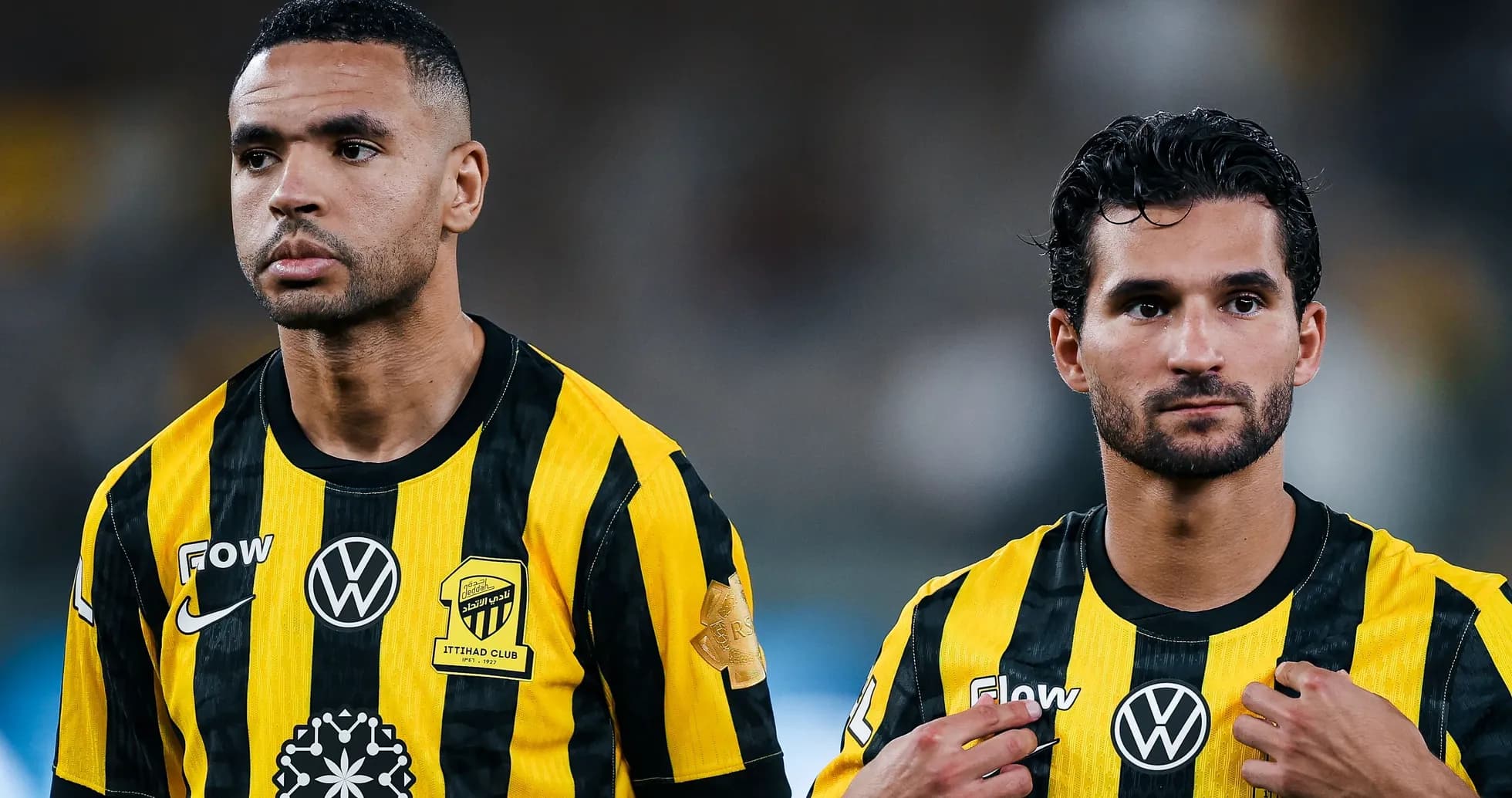 Two players in black and yellow jerseys looking focused Two players in black and yellow jerseys looking focused