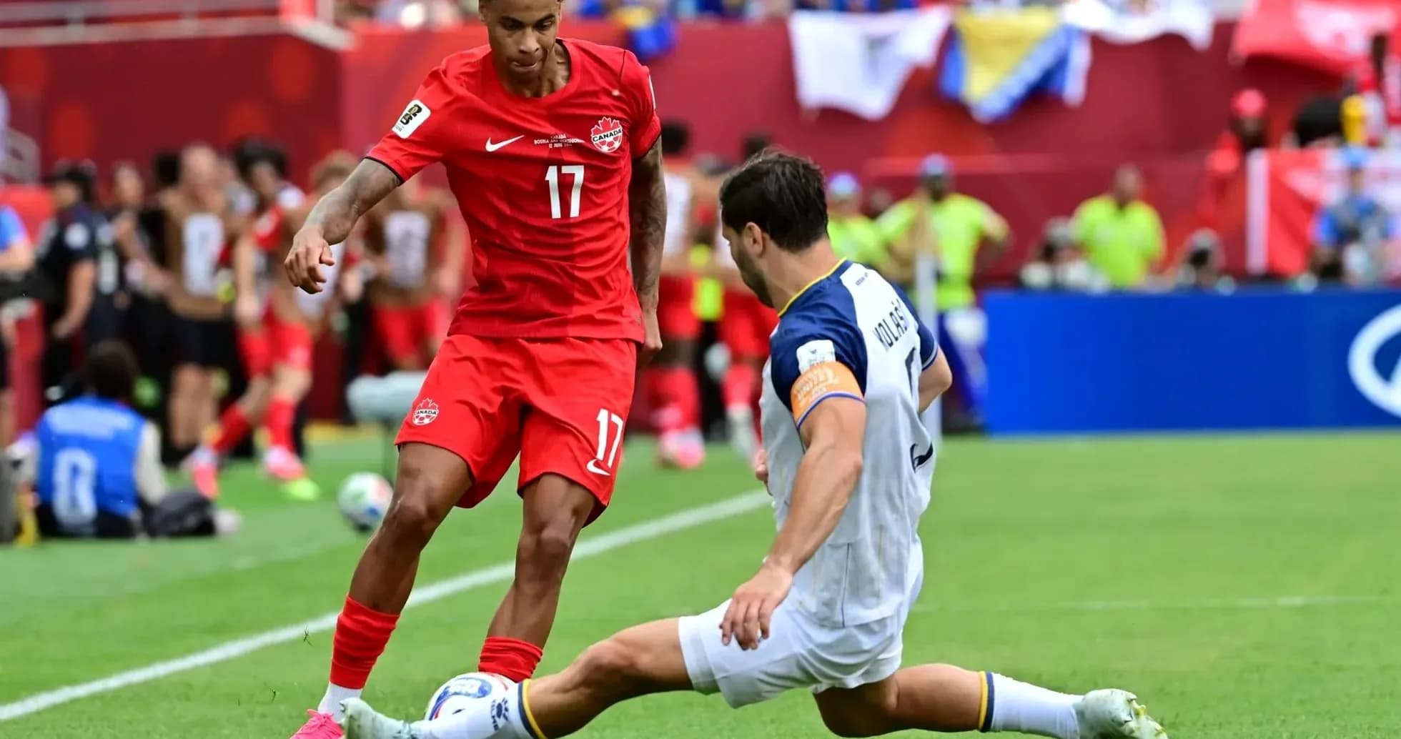 Canada player dribbling against Bosnia defender Canada player dribbling against Bosnia defender