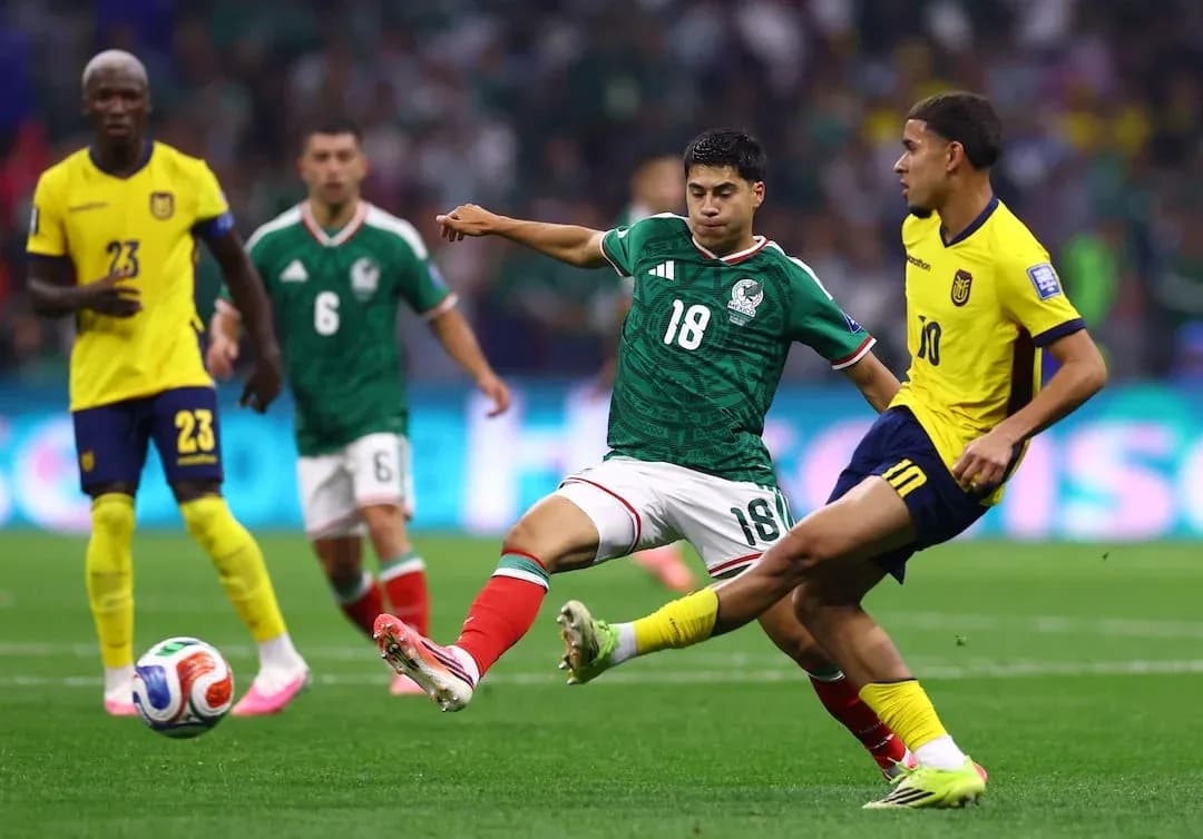 Mexico player tackling Ecuador opponent during match Mexico player tackling Ecuador opponent during match