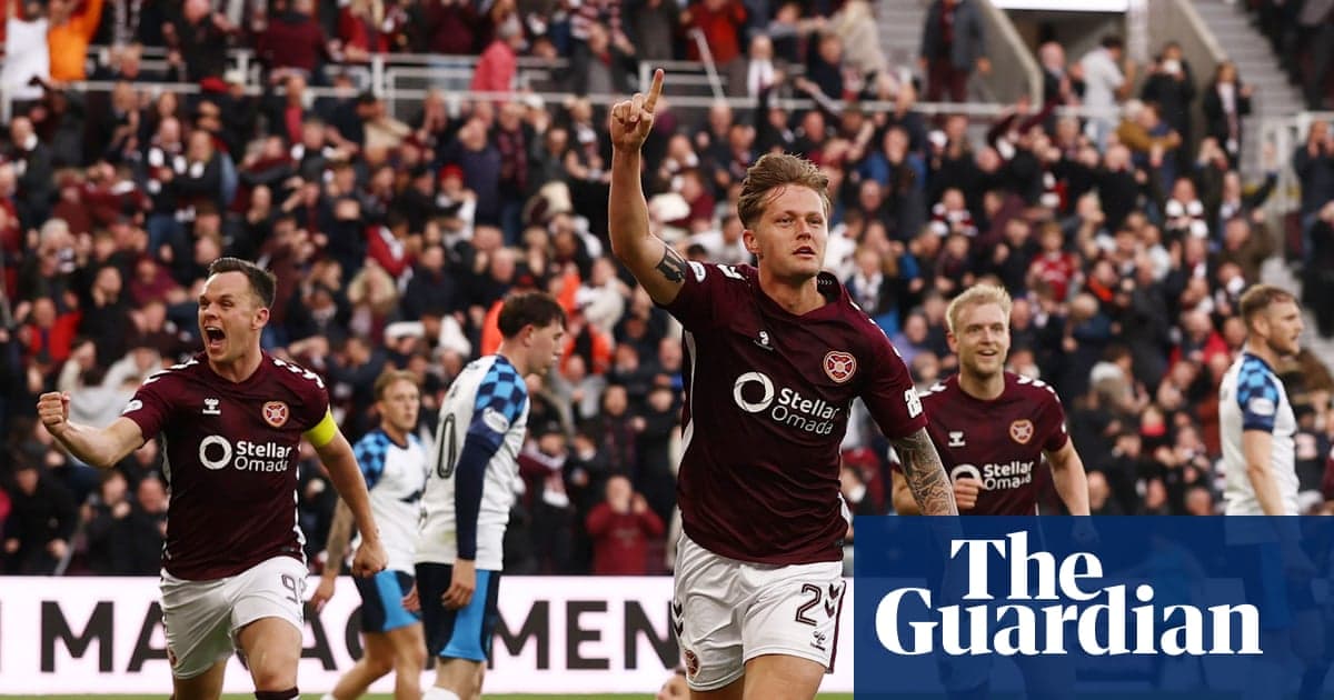 Hearts player celebrating goal with teammates in stadium Hearts player celebrating goal with teammates in stadium