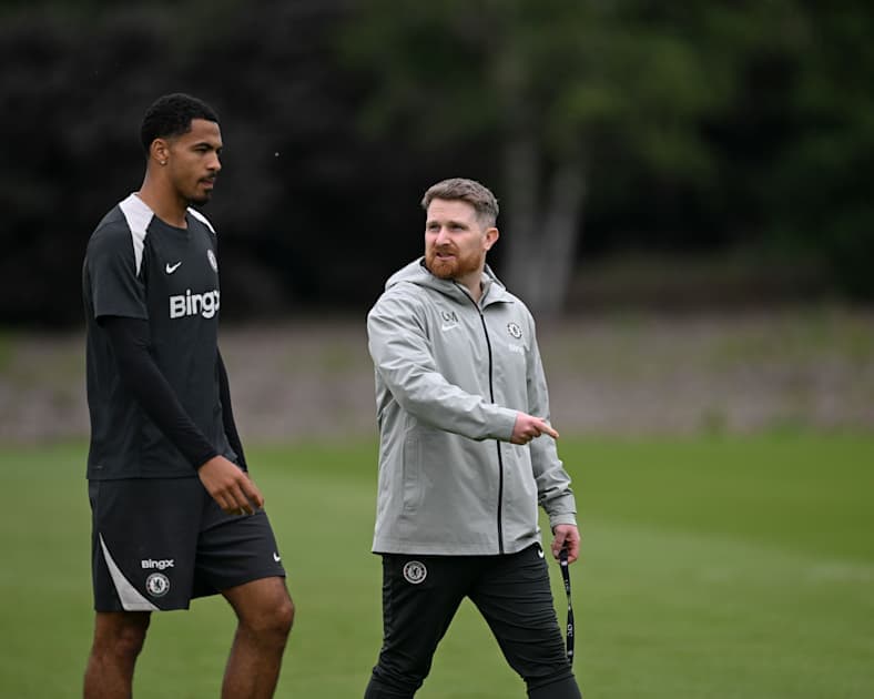 Player and coach walking on training pitch Player and coach walking on training pitch