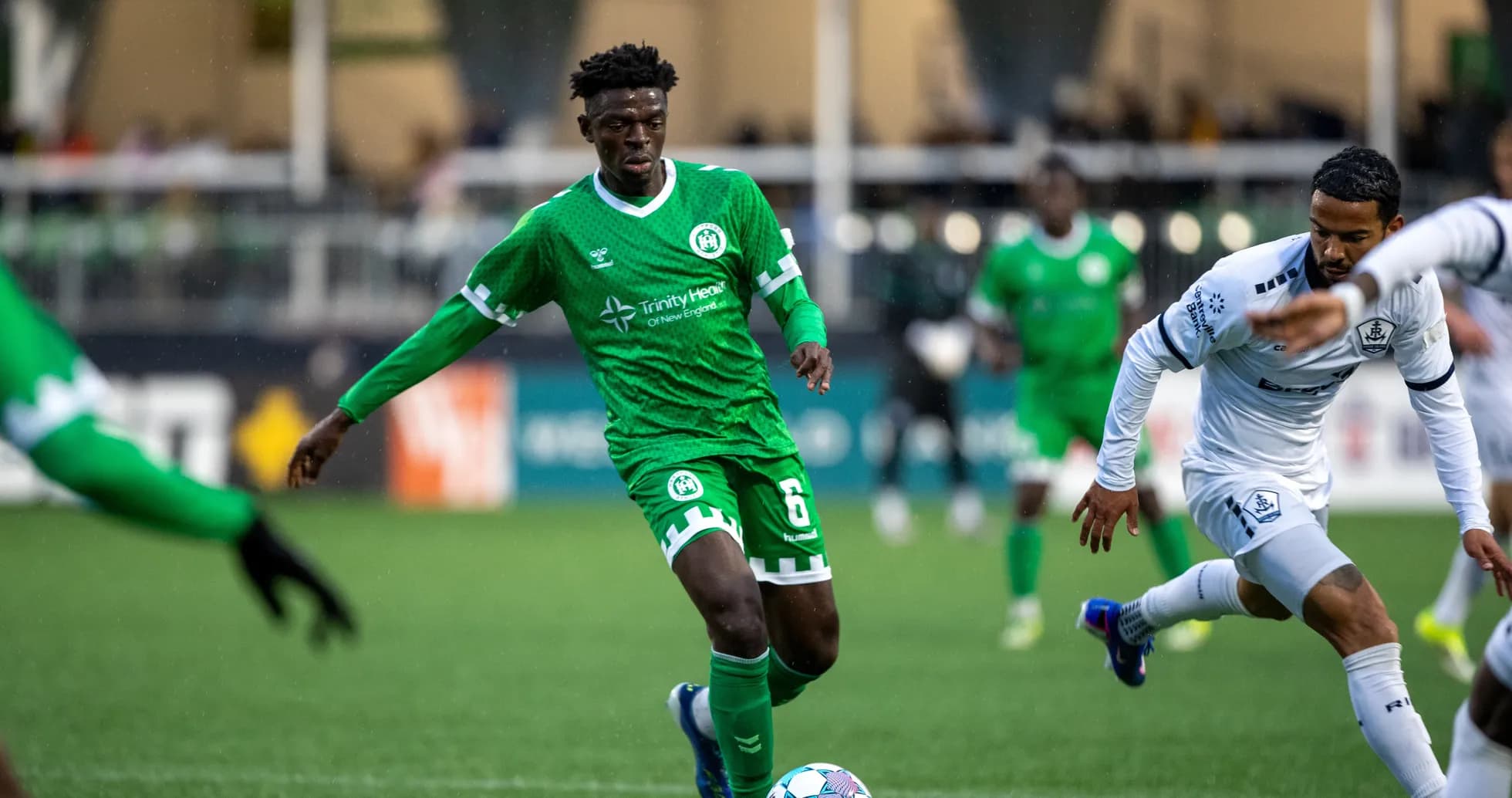Player in green kit dribbling the ball during match Player in green kit dribbling the ball during match