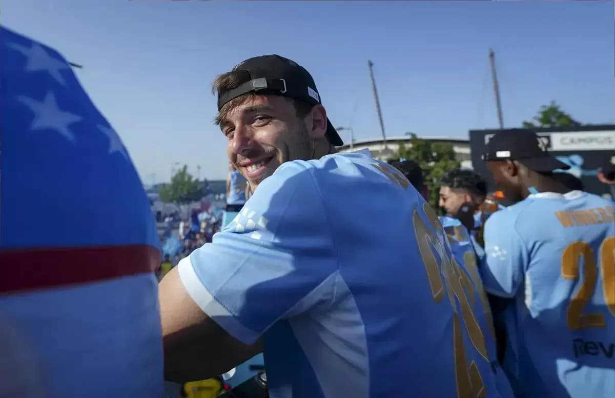 Player smiling during celebratory event in blue jersey Player smiling during celebratory event in blue jersey