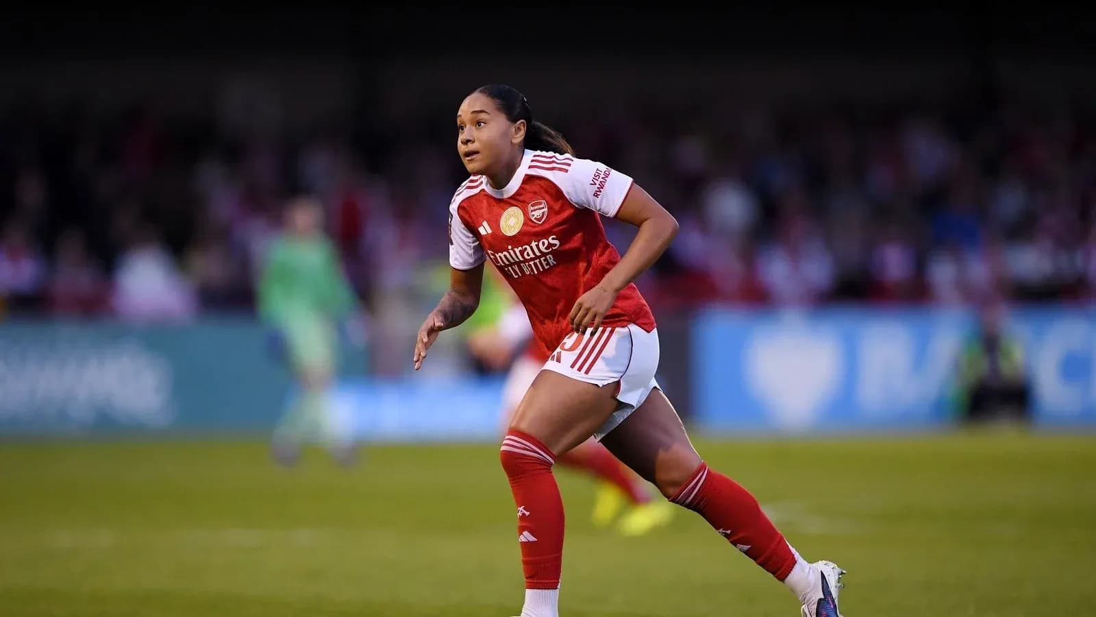 Player in Arsenal kit running on the pitch Player in Arsenal kit running on the pitch