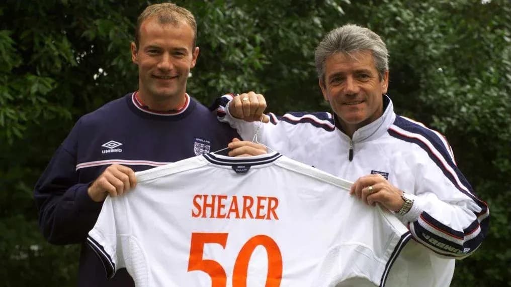 Two men holding a football jersey with 'SHEARER 50' Two men holding a football jersey with 'SHEARER 50'
