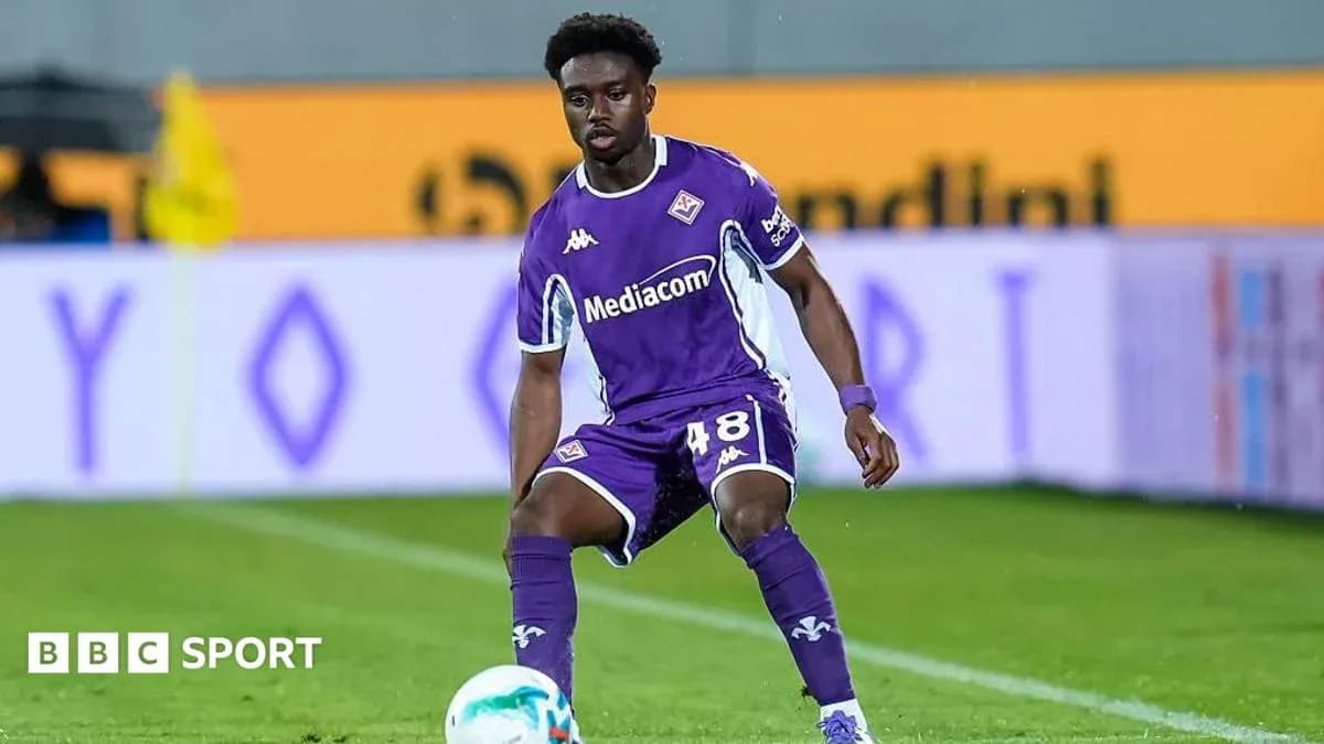 Player in purple jersey controlling the ball on field Player in purple jersey controlling the ball on field