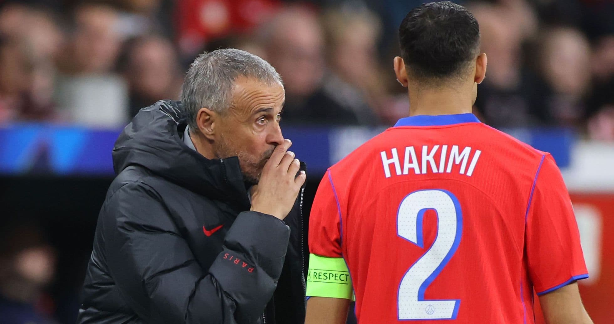 Coach giving instructions to player Hakimi on field Coach giving instructions to player Hakimi on field